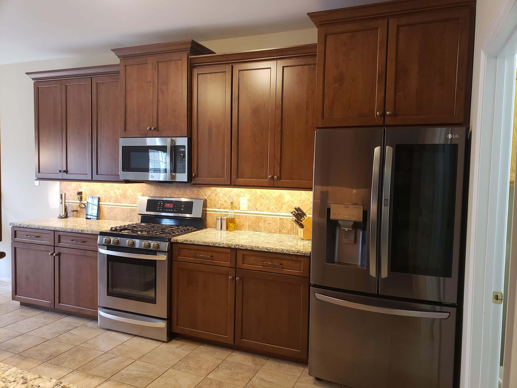 After Picture: 42" Wall cabinets with raised and bumped out fridge and microwave. Cherry Refacing